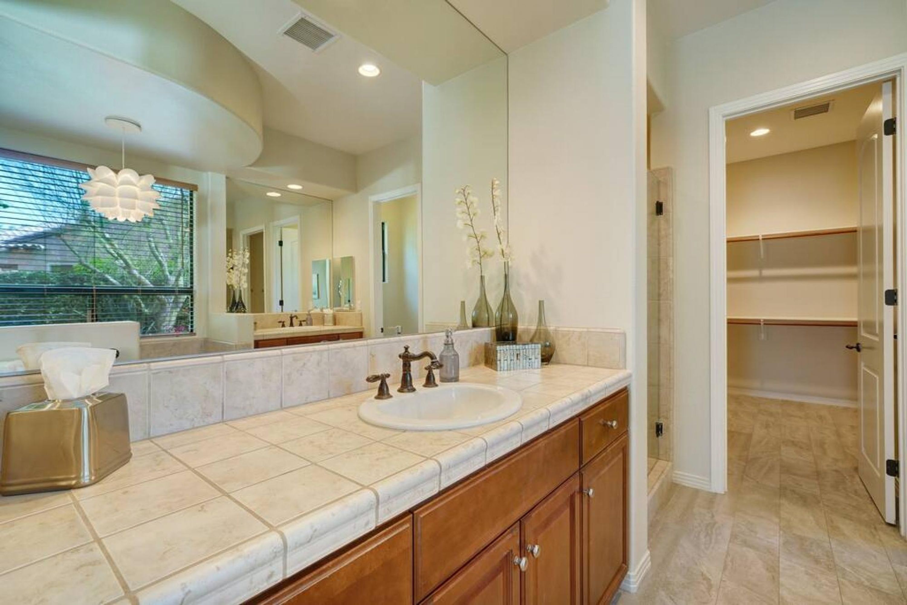 A modern bathroom with a double sink, vanity, and a large mirror.