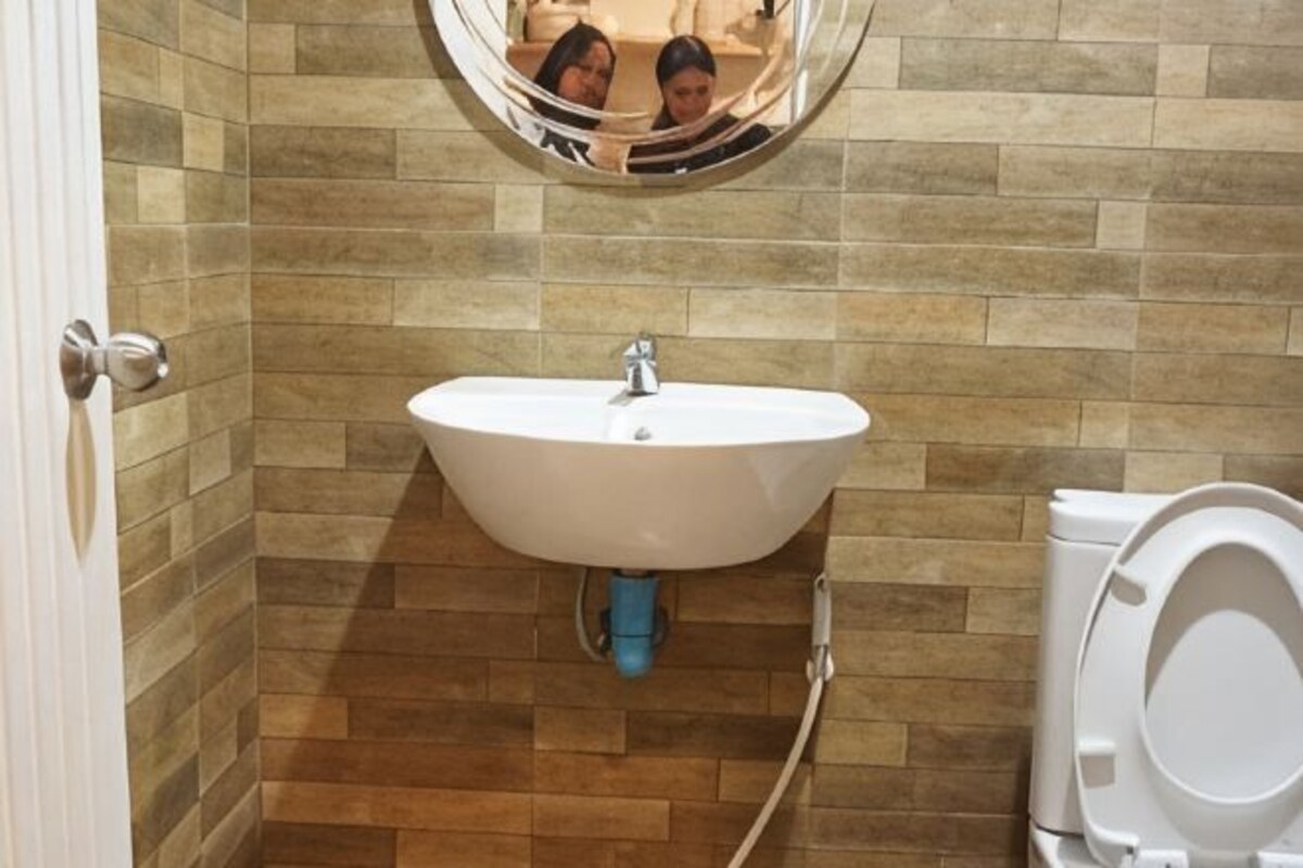 A bathroom with a white sink, a toilet, and a mirror above the sink.