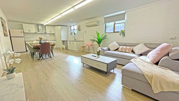 A modern apartment with a dining area, kitchen, and living room.