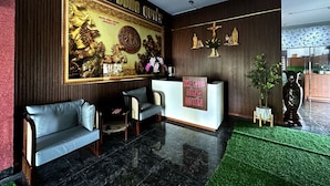 Ein Hotel-Empfangsbereich mit einer großen Schilder, auf denen "HOTEL DUNG QUYEN" steht, einer Rezeption, einem Sitzbereich mit Stühlen und einer Wandverzierung mit einer goldenen Pferdeskulptur.