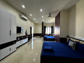 Una habitación de hotel con cama, escritorio, silla, televisor y ventana.