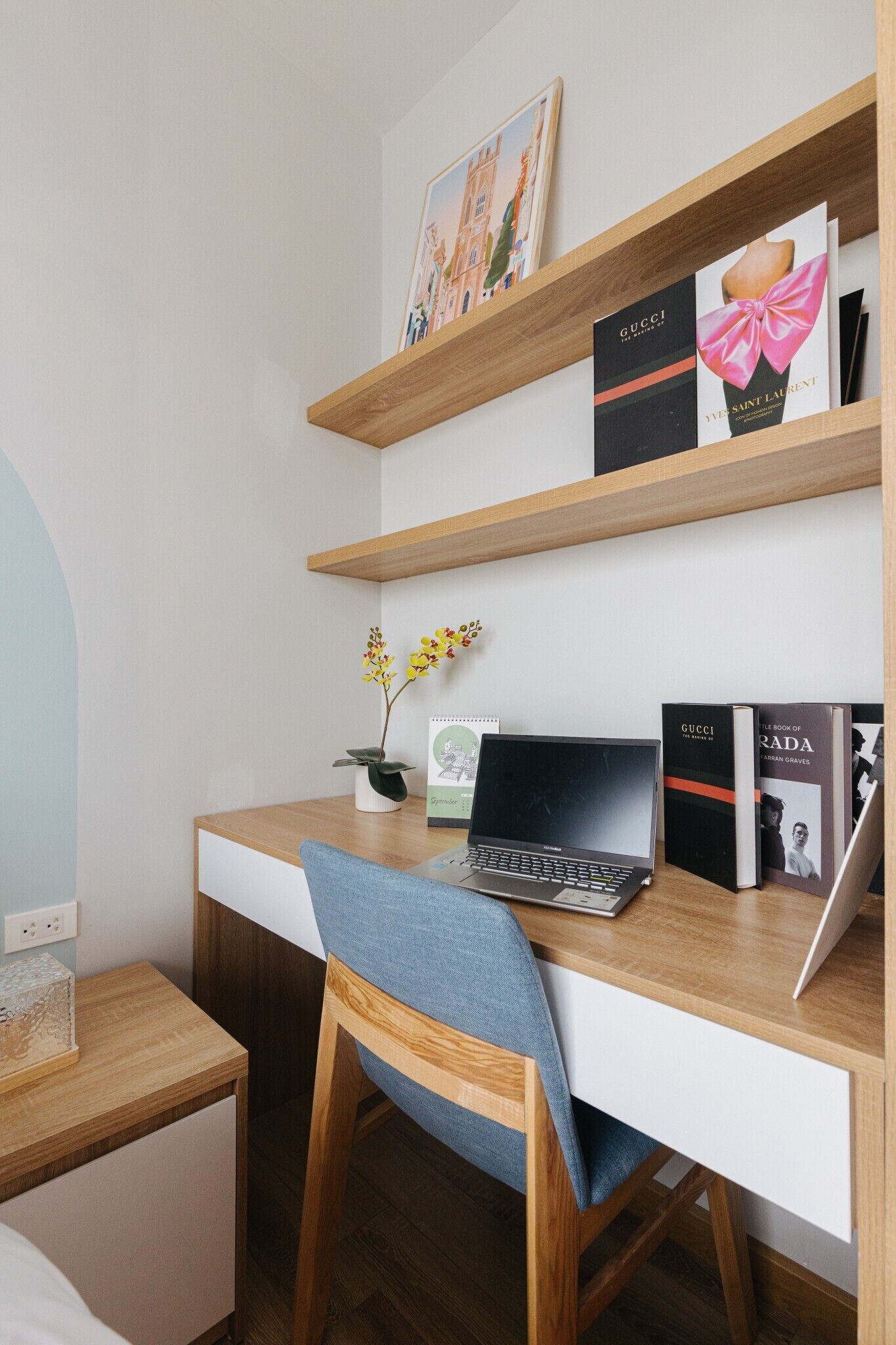 Un espacio de trabajo moderno con un escritorio de madera, una computadora portátil y libros en estanterías.