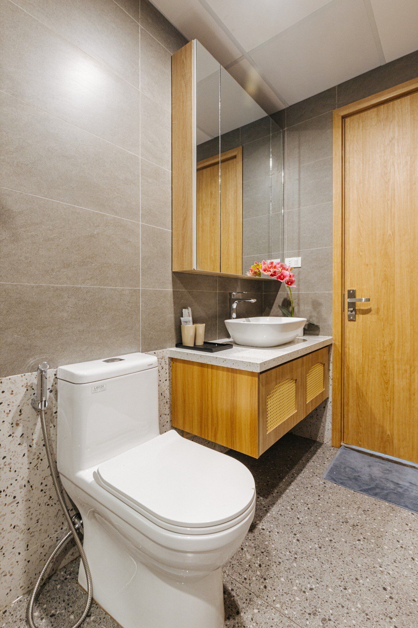 Une salle de bain moderne avec des toilettes, un lavabo et un miroir.