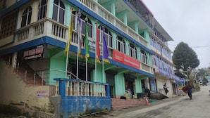 Een meerlaags gebouw met een bord waarop 'Hotel Tawang Holiday' staat.