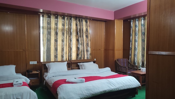 Een hotelkamer met twee bedden, een bureau, een stoel en een garderobe.