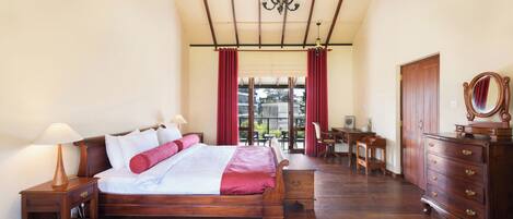 A bedroom with a wooden bed, a desk, and a wardrobe.