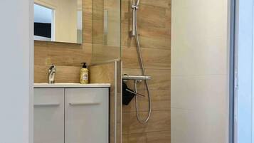 Een douche, handdoeken, zeep, shampoo