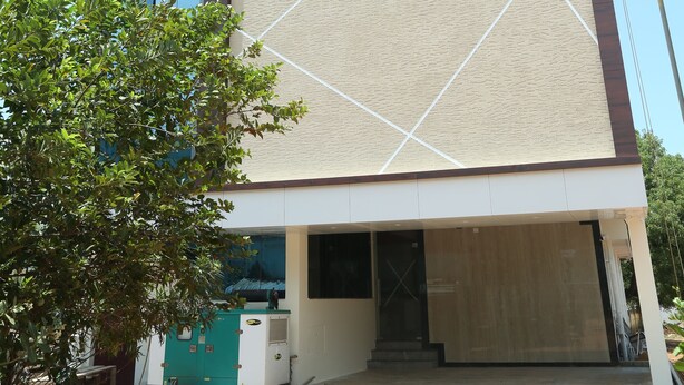 Um edifício moderno com fachada de vidro ampla e parede com padrão geométrico.