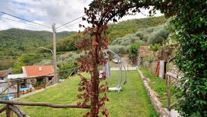 A rural setting with a grassy area, a stone wall, and a wooden fence.