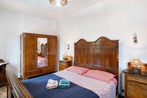 A bedroom with a wooden bed, a wardrobe, a nightstand with a lamp, and a mirror. - Apartment "Câ de Bacî" with Private Terrace (Vessalico)