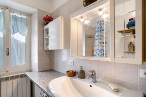 A bathroom with a sink, mirror, towel rack, and a window with curtains. - Apartment "Câ de Bacî" with Private Terrace (Vessalico)