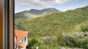 A mountainous landscape with a building featuring a tiled roof and satellite dish.