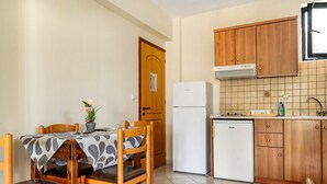 Una cocina compacta con gabinetes de madera, un refrigerador y un salpicadero de azulejos.