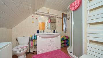 Une salle de bain avec des toilettes, un lavabo et une douche.