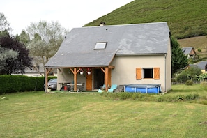 Une maison avec un toit en pente, une véranda et une petite fenêtre.