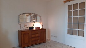A room with a wooden cabinet, a mirror, a plant, and a door with glass panels. - Lake House Lebehn (Lebehn)