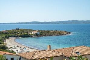 A coastal view with a beach, houses, and a clear sky. - Holiday Home "Cà du Savio" with Sea View and Wi-Fi (Calasetta)