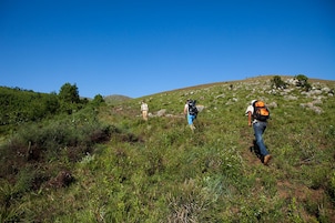 Paisaje montañoso con tres excursionistas.