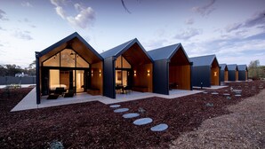 A modern building with multiple rooms, each with a sloped roof and large windows. - Par Five Shacks (Berri)