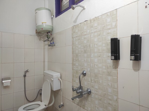 A bathroom with a toilet, a bidet, and a water heater.