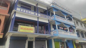 A multi-story building with a sign for 'Buddha Hotel' and 'M. Sakur Tailor'. - Eight Lucky Homestay (West Kameng)