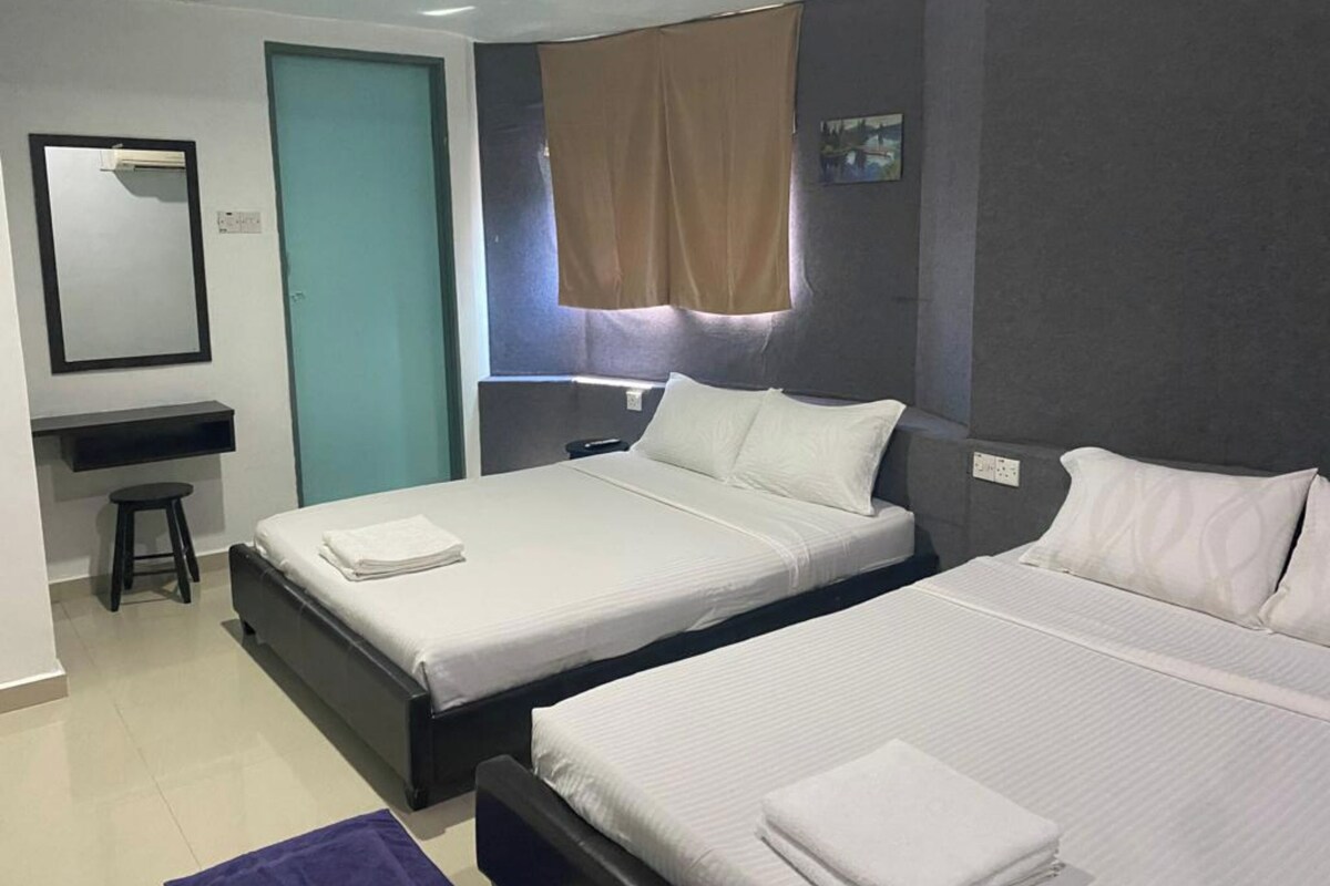 Une chambre d’hôtel avec deux lits, un bureau et une chaise.