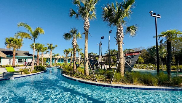 A swimming pool with palm trees and a sign that reads "Mayan Ruins". - Family-friendly escape w/ resort access & pool (Kissimmee)