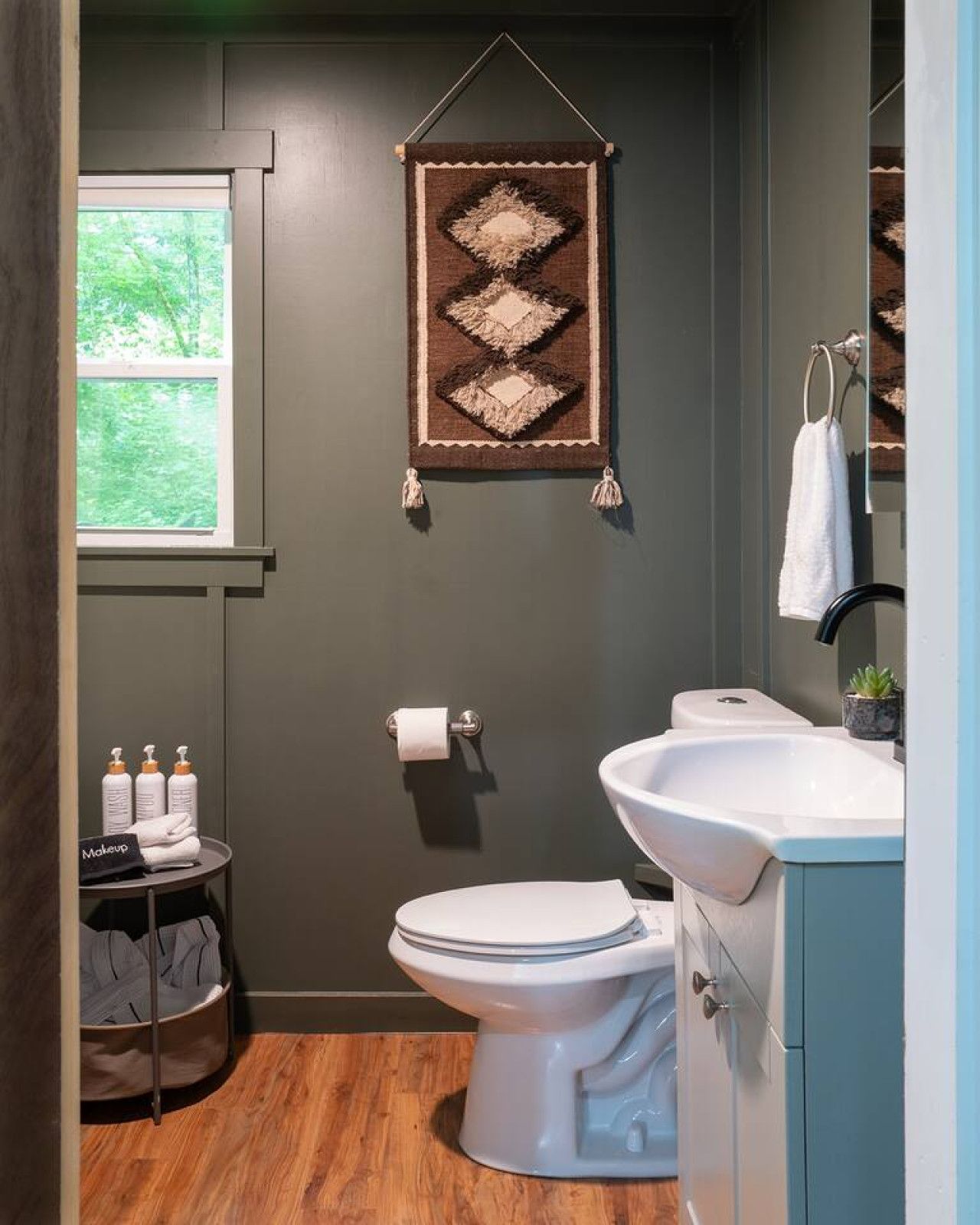 Une salle de bain moderne comprenant des toilettes, un lavabo et un élément décoratif suspendu.