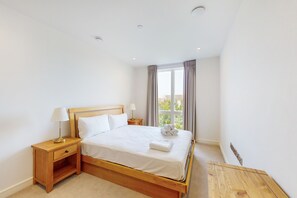 Cozy retreat with a single bed, nightstand, and window with curtains.