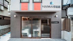 Un edificio con fachada de tejas, entrada de vidrio y un letrero que indica 'Regency nippon'.