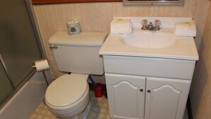 Ein kleines Badezimmer mit Toilette, Waschbecken und Schrank.