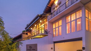 A two-story building with a garage and a balcony. - Swarga Villa (Kandy)