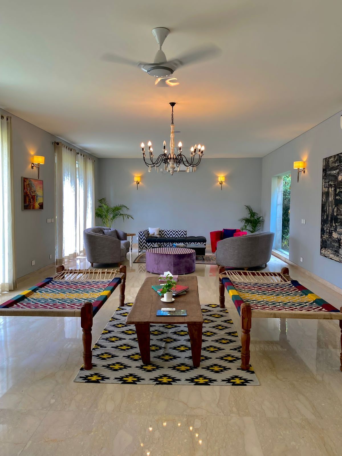 A spacious living room with a chandelier, two sofas, a coffee table, and a patterned rug.