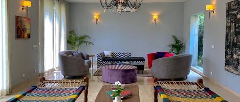 A spacious living room with a chandelier, two sofas, a coffee table, and a patterned rug.