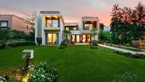 Una casa moderna de dos pisos con un césped y jardín bien cuidados.