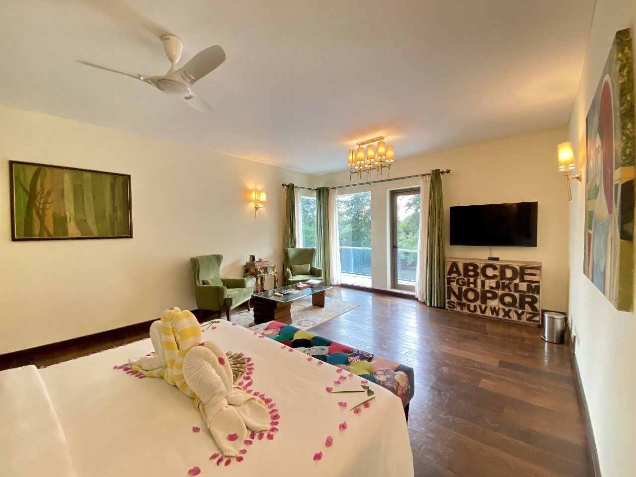 A hotel room with a bed, a television, a desk, and a view of the outdoors.