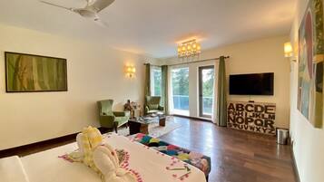 A hotel room with a bed, a television, a desk, and a view of the outdoors.