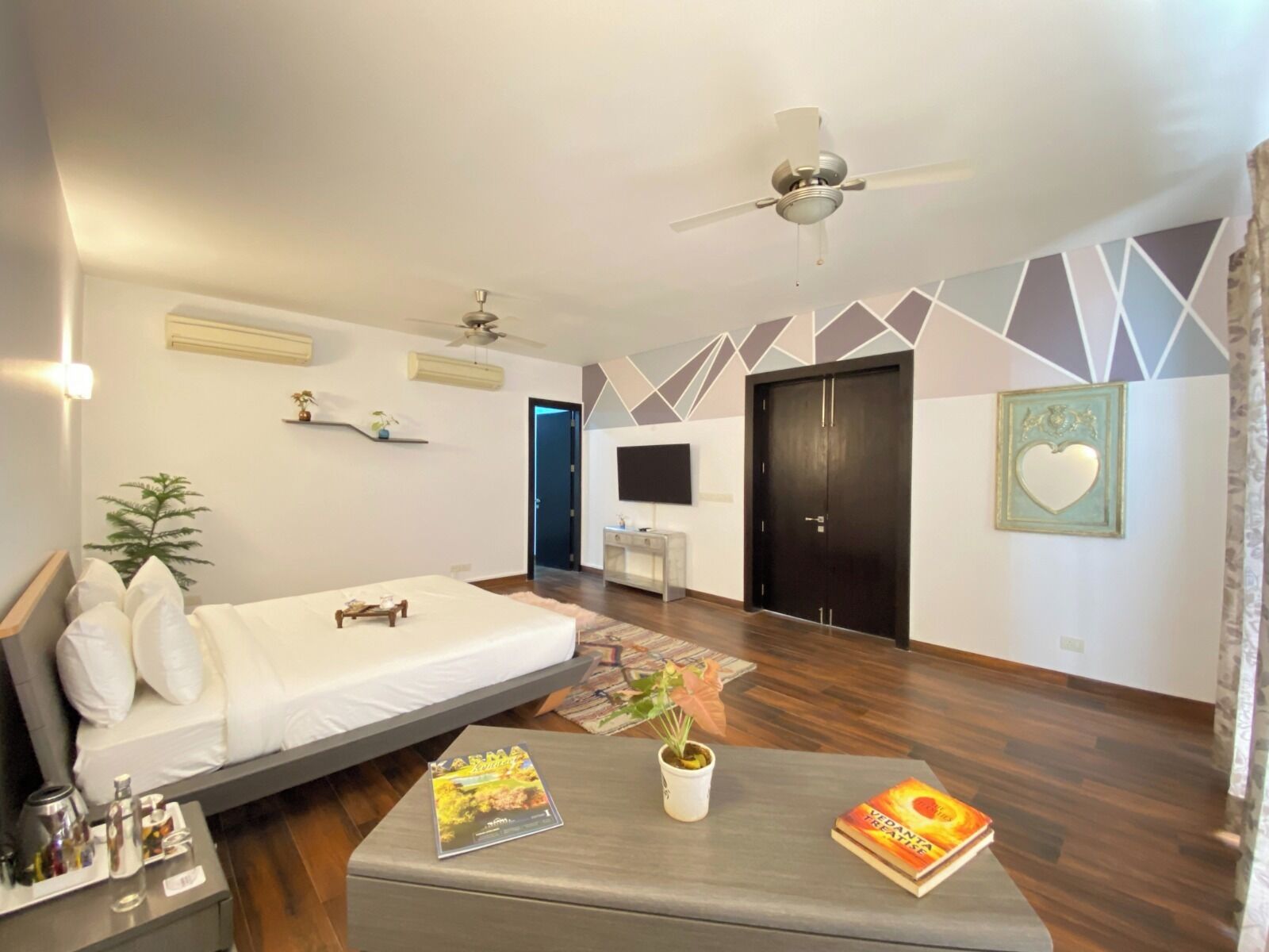Un dormitorio moderno con cama, mesita de noche y ventilador de techo.