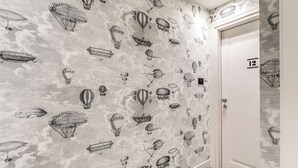 A hallway with a patterned wallpaper featuring various hot air balloon designs. - Sospeso Boutique Hotel (Milan)