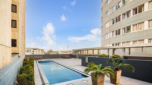 A rooftop pool with a view of the city skyline, surrounded by modern buildings.