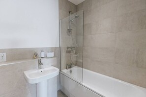 Bathtub, hair dryer, towels, shampoo
