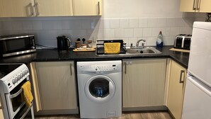 A compact kitchen with a microwave, toaster, sink, and dishwasher. - Perfect Location Near Beach, Shops and Restaurants (Eastbourne)