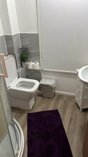 A bathroom with a toilet, bidet, and a small trash bin. - Perfect Location Near Beach, Shops and Restaurants (Eastbourne)
