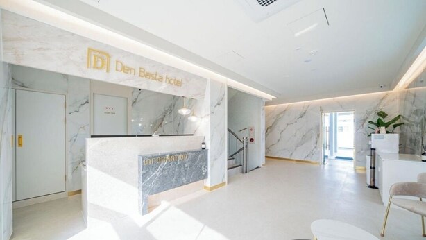 A modern hotel reception area with a marble reception desk, a staircase, and a seating area. - Denbastar Hotel-Kyungnam University Branch (Changwon)