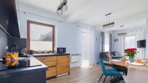 A modern kitchen with a central island, wooden cabinets, and a dining area with a table and chairs.