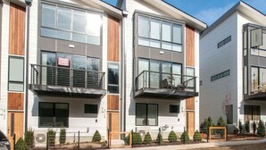 En moderne, flersidet boligbygning med altaner, store vinduer og et rent, moderne design.