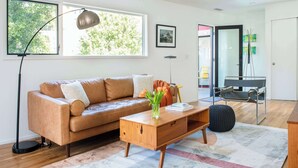 Un salon moderne avec un canapé en cuir, une table basse en bois et un lampadaire.