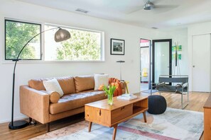 A modern living room with a leather sofa, a wooden coffee table, and a floor lamp.