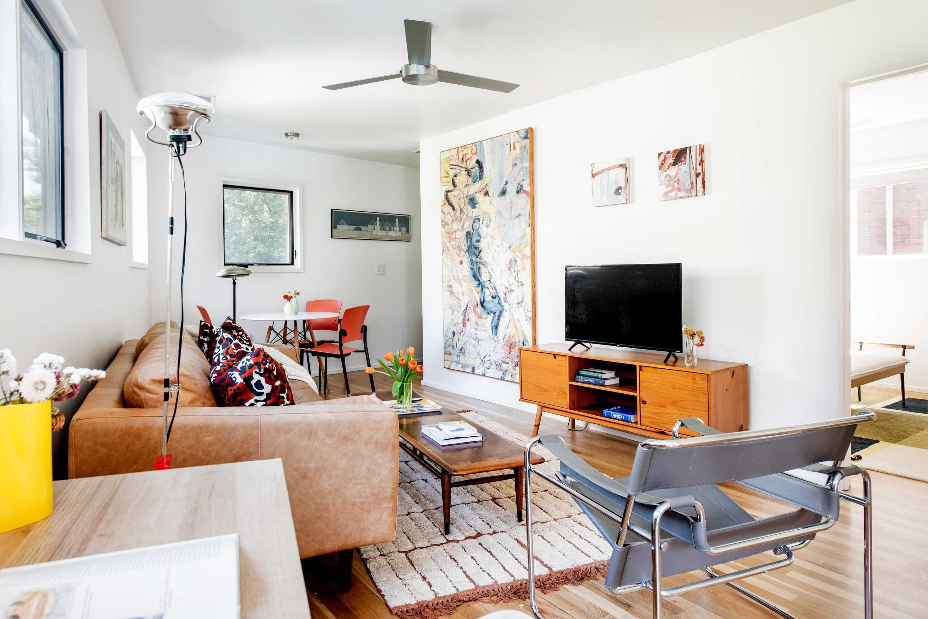 A modern living room with a sofa, coffee table, and a TV on a wooden cabinet.