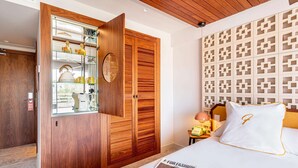 Een slaapkamer met een houten garderobe, een nachtkastje met een lamp en een bed met een tijdschrift.